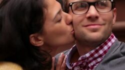 New York couple in love exchange kisses on the cheek and nuzzle close on stoop of brownstone apartment (dolly-shot) Stock Footage