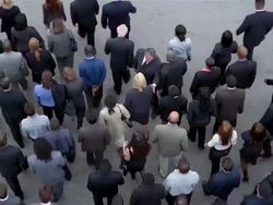 High angle wide shot overhead view of crowd of businesspeople walking / man walking towards crowd Stock Footage