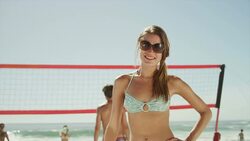 Confident woman on beach with friends playing volleyball Stock Footage