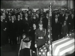 Jacqueline and Caroline kneel beside U.S. President John F. Kennedy's flag-draped coffin as it lies in state in rotunda of Capitol Building. News Clip