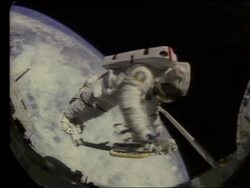 Astronaut working in space with Earth in background Stock Footage