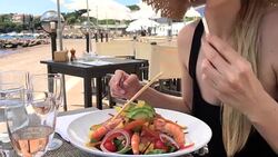 Young woman eating fresh salad front of Mediterranean sea Stock Footage