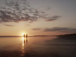 Costa Rica, Esterillos Beach, Couple walking on beach at sunset Stock Footage