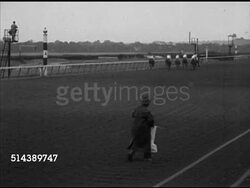 1953: BELMONT PARK: SUBURBAN HANDICAP: LS Horses going into starting gate, VS Track announcer Fred Caposela in booth, 'They're off', VS RACE, 'Tom Fool' taking off out in front, HA LS Racing backstretch, battle for third position. [VO Fred Caposela] Instructional Video