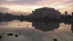 A large government building reflects in water at golden hour. Stock Footage