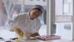 Baker squeezes dots of yellow custard around beautiful cake dish Stock Footage