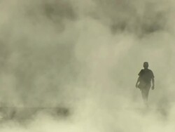 Long Shot static - A park ranger walks through clouds of steam in Yellowstone National Park, Wyoming. / Yellowstone National Park, Wyoming, USA Stock Footage