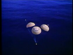 AERIAL of space capsule with parachutes splashing down / Apollo 17 Stock Footage
