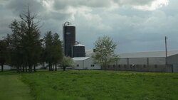 Dairy farm with grain silo in front of a lush field Stock Footage