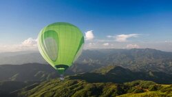 Green Hot air balloon fly over mountain Stock Footage