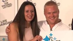 Lottery winners pose with giant cheque News Clip