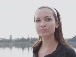 CU Shot of young female jogger relaxes at city water front after her jog and drinking water in bottle / Portland, Oregon, United States  Stock Footage