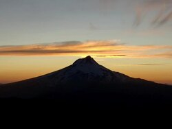 Mount Hood silhouetted against golden sunset and clouds Stock Footage