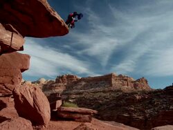 WS SLO MO Man parachuting off large cliff in desert / Moab, Utah, United States   Stock Footage