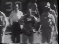 B/W 1961 astronaut, Gus Grissom, in spacesuit walking on deck of ship after flight / Mercury 4 Stock Footage