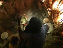 Woman stirring pastry with small child next to her Stock Footage