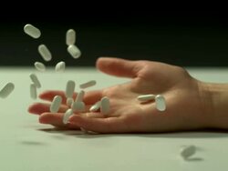High speed Young lady's hand falls and drops white pills, split background Stock Footage