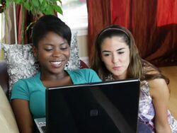 Two female friends chatting on laptop Stock Footage