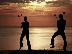 MS Sihouetted couple perform poi dance together with fireballs in front of fiery sunrise and ocean / Montezuma, Costa Rica Stock Footage