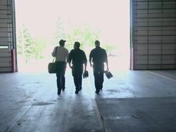 MS SLO MO Three silhouetted workers walking away / Chelsea Michigan, United States Stock Footage