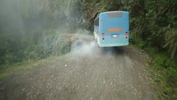A tour bus turns a sharp corner in a lush canyon in Bolivia. Stock Footage