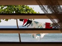View of the ocean and drying rack through a window with colonial style sun shutter, Cuba Stock Footage