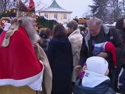 christmas market, santa claus with gifts, mother with her child, some other people Stock Footage