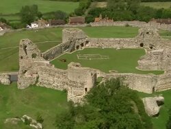 Aerial over Pevensey Castle / zoom out landscape / East Sussex, England Stock Footage