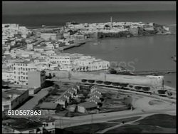 1951: RABAT, FRENCH MOROCCO: HA XWS Coastal city of Rabat on Atlantic Ocean. French flag on building. US Major General Pierpont M. Hamilton walking up, saluting & shaking hands w/ French General Challes. Instructional Video