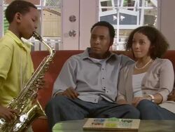 MS, PAN, couple listening to son (6-7) play saxophone in living room, Westfield, New Jersey, USA Stock Footage