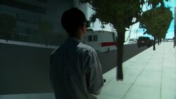 A gamer wearing virtual reality glasses appears to walk through a video game on a big screen. Stock Footage