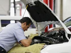 MS Mechanic working on engine of car and removing part from car / Seattle, Washington, United States  Stock Footage