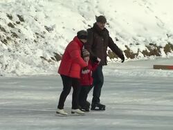 Nymphenburg, two adults and a child on ice skates, snow, frozen river Stock Footage