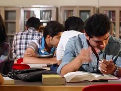 Mischievous boy sitting in the library Stock Footage