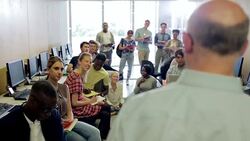 Rear view of mature teacher talking to students in computer class Stock Footage
