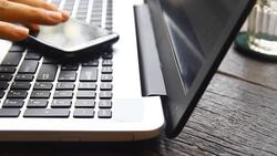 businessman hand hold phone and use laptop Stock Footage