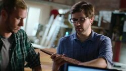 Wood shop owner teaches young workers about designing and crafting custom skateboards Stock Footage