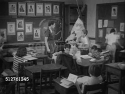 1953: THIRD/FOURTH GRADE: INT School room w/ teacher talking w/ students, boy holding Native American headdress [SOT Dr. Spock saying good school, trained teacher, small class much can be taught...will really learn...letting children decide...]... Instructional Video