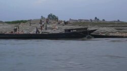 View from a speedboat in the Bangladesh delta as it passes labourers install flood and erosion protection on the river bank Stock Footage