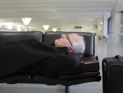 MS Middle aged traveling businessman resting on bench inside airport / Minneapolis, Minnesota, United States Stock Footage