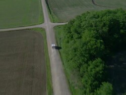 Ambulance driving through an intersection of gravel roads Stock Footage