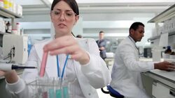 Scientist pouring liquid into test tube in laboratory Stock Footage