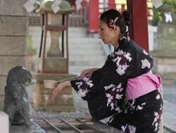 MS Mature woman in yukata (Japanese costume) is at shrine's chozubachi (water basin) and uses water dippers to purify herself before entering shrine / Tokyo, Japan Stock Footage