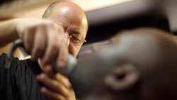 New York City barber shaves customer's beard with electric clippers Stock Footage