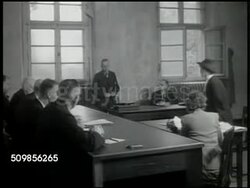 1946: DENAZIFICATION of GERMANY: Paperwork 'Military Government of Germany questionnaire (fragebogen)'. VS Denazification war crimes trial, man standing, woman standing, people seated in courtroom, judges at table, German policeman w/ audience BG. Instructional Video