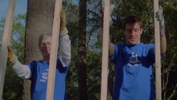 Volunteers lift frame together Stock Footage