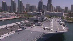 The USS Midway CV-41 fronts the San Diego skyline. Stock Footage