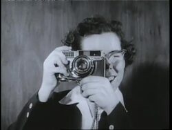 Olympic skater Cornelia Pooch Harrington takes a picture with a camera. News Clip
