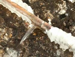 Frozen Cracked Copper Water Main Pipe Leaking Below Ground Stock Footage