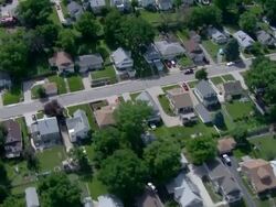 Older middle income residential neighborhood with trees and green lawns Stock Footage